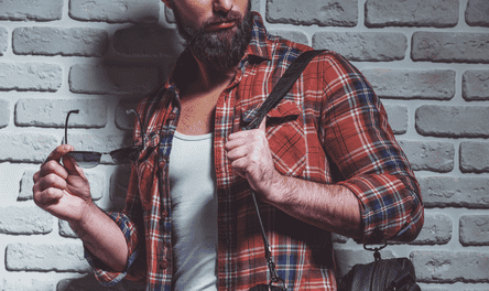 man with nice beard standing against exposed brick