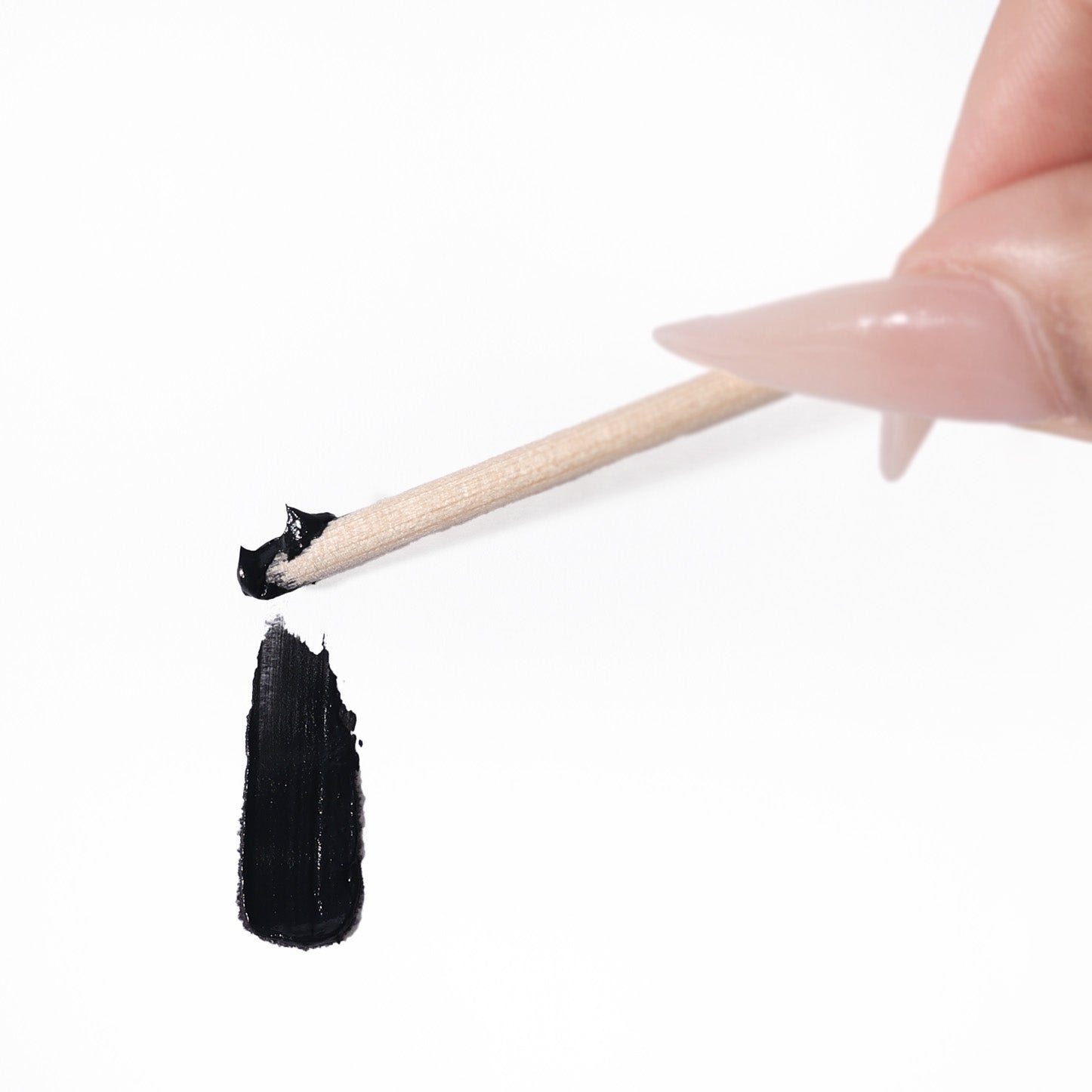 small wooden applicator swiping black tint