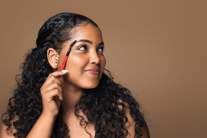 happy woman brushing her eyebrows