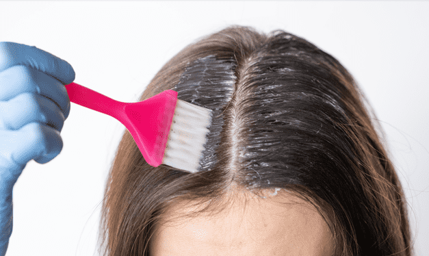 woman applying hair dye to roots
