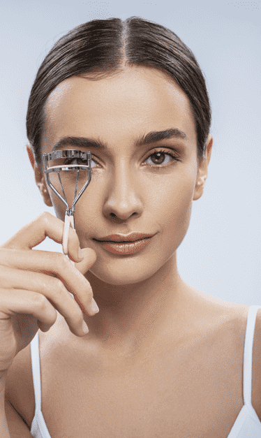 Woman curling her lashes