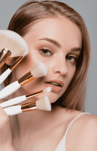 Beautiful woman holding make-up brushes