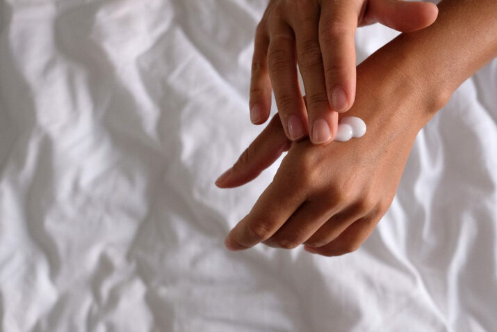 woman applying moisturizer on hands