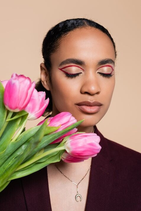 woman with red eye makeup and pink flowers