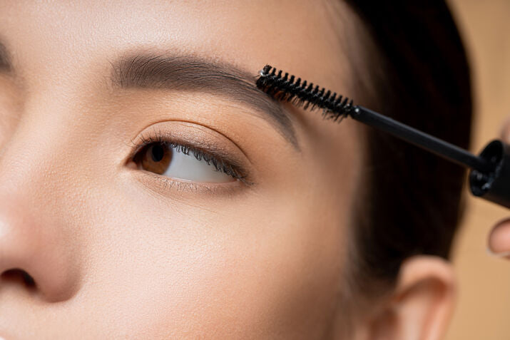 Woman brushing through eyebrows