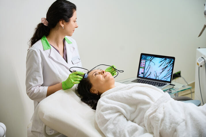 professional conducting a scalp analysis on women