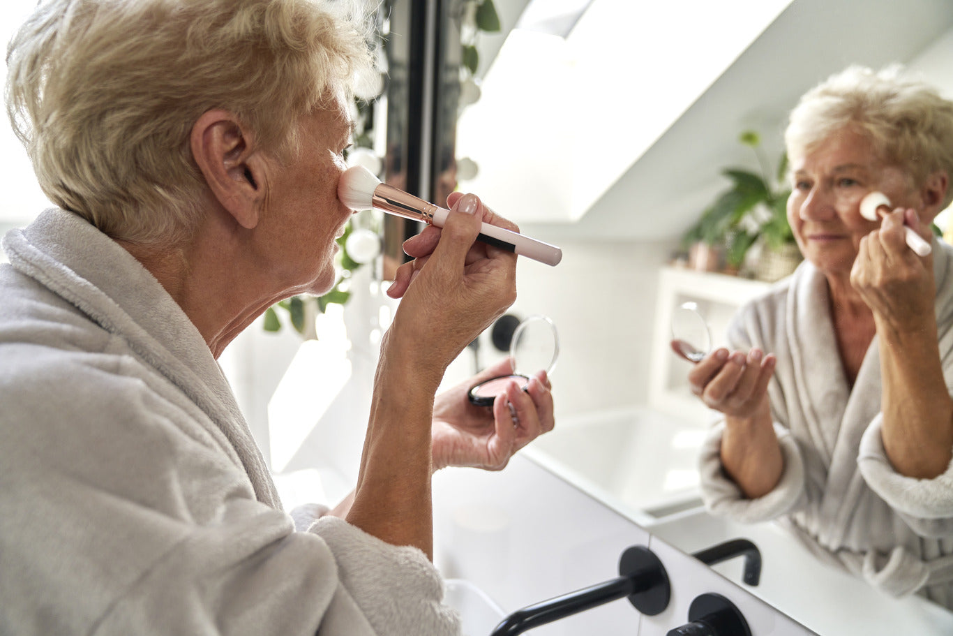 Older woman applying makeup