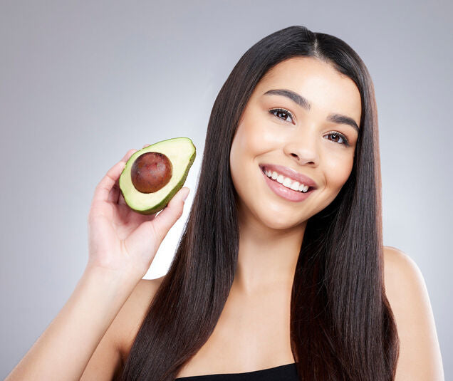 Woman happily holding up an avocado