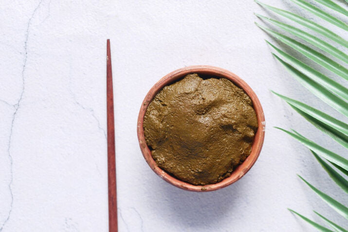 wooden bowl with henna on a table