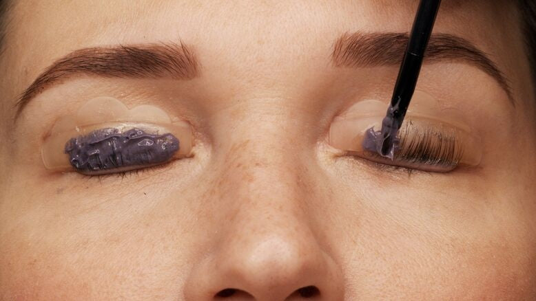 Woman tinting her eyelashes