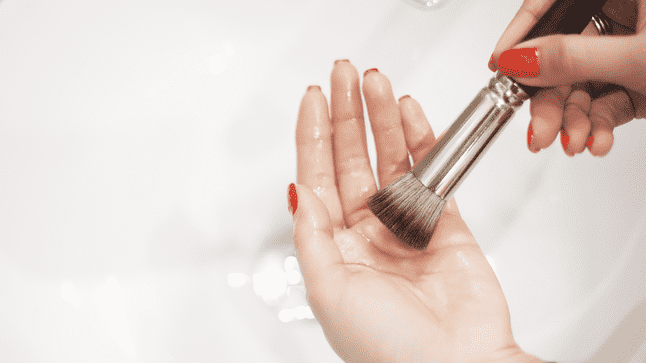 woman cleaning makeup brush