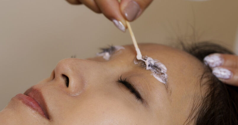 Woman applying eyebrow lightening product