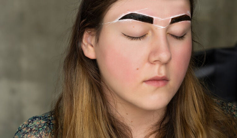 woman tinting her eyebrows dark brown