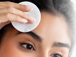 woman removing makeup with cotton pad