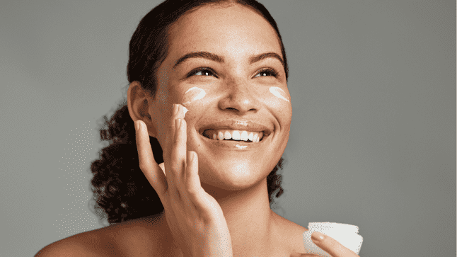 Woman putting on face cream 