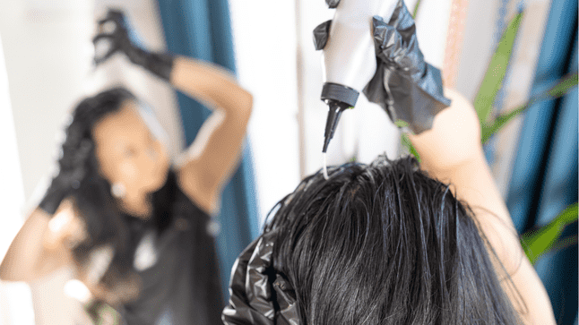 woman applying hair dye to her scalp