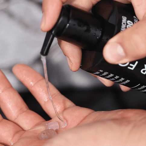 Male squirting Silver Fox shampoo onto hand