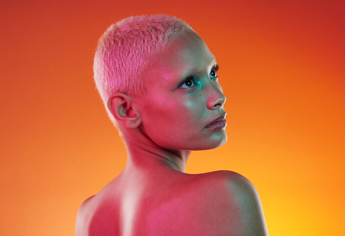 Woman with short bleached hair with orange background