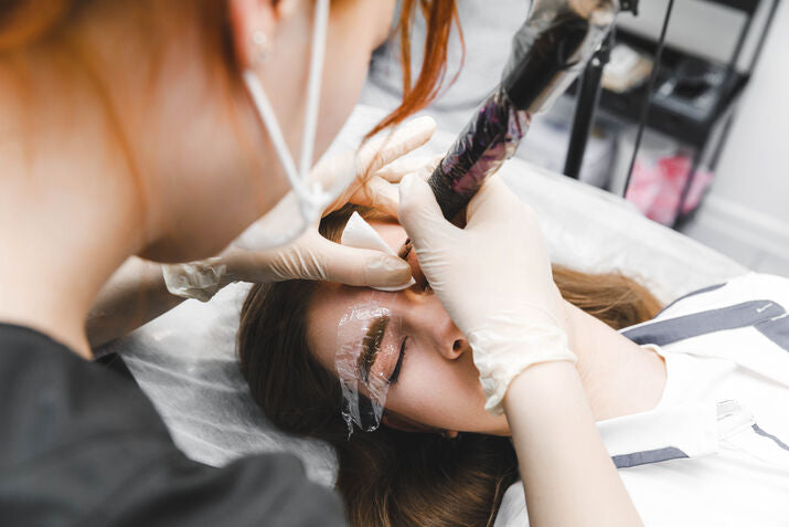 woman getting brows tattooed