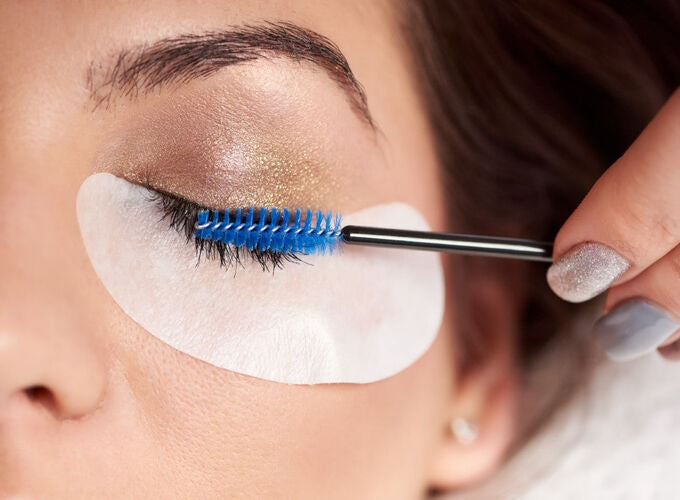 woman applying eyelash tint at salon