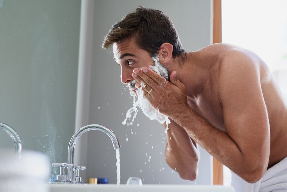 Man washing his beard in the bathroom