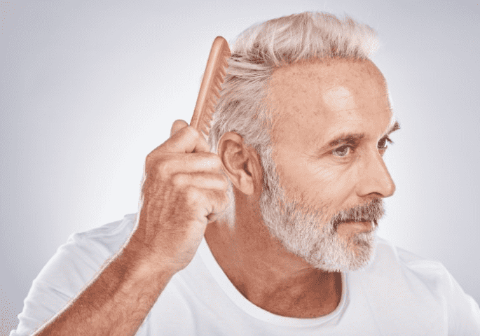 Older man combing his hair