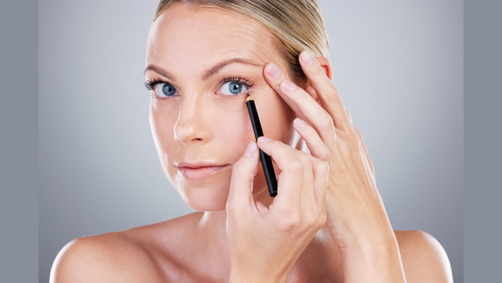 woman applying brown eyeliner 