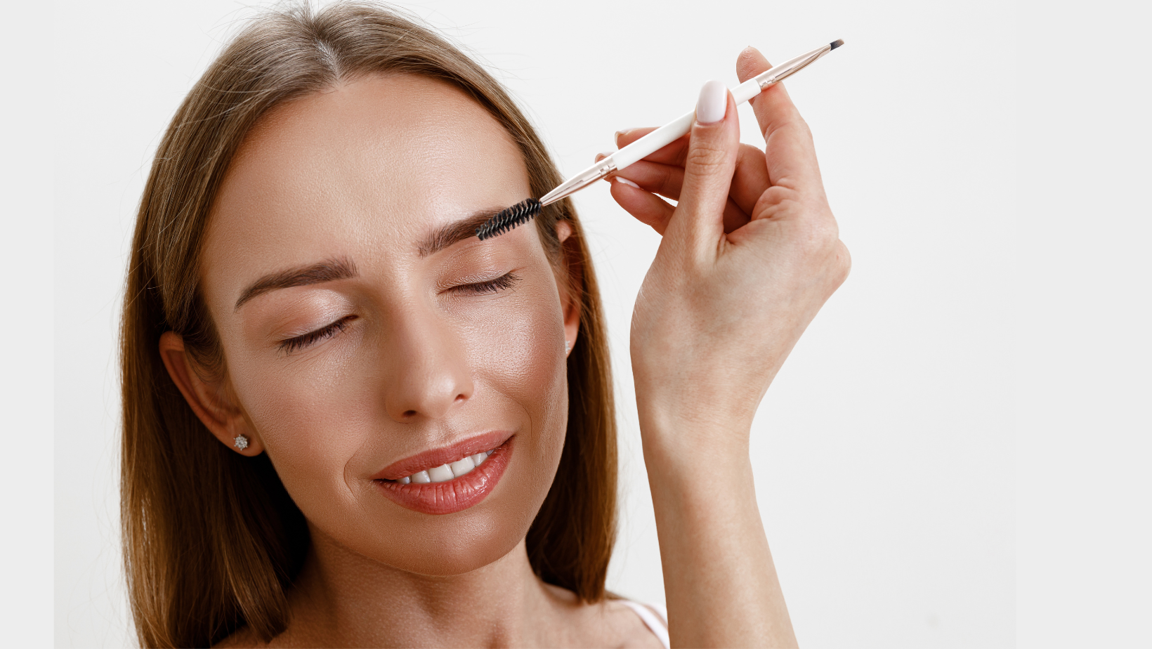 woman brushing her dark eyebrows 