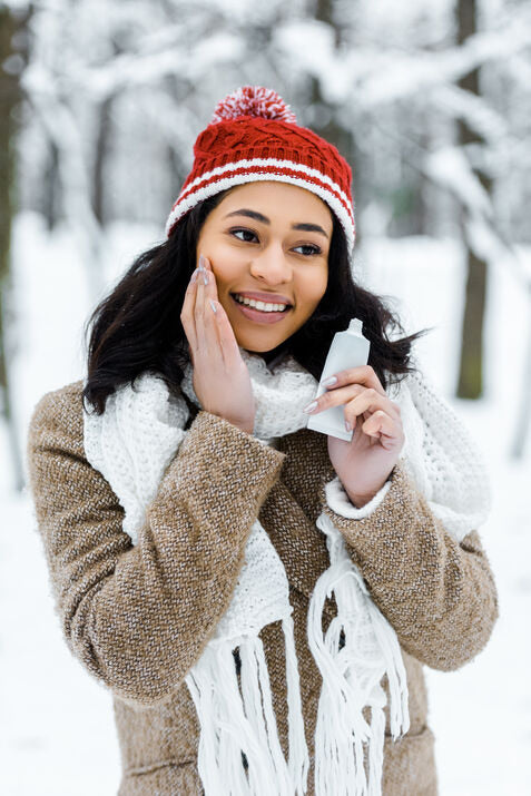 woman in winter applying skincare