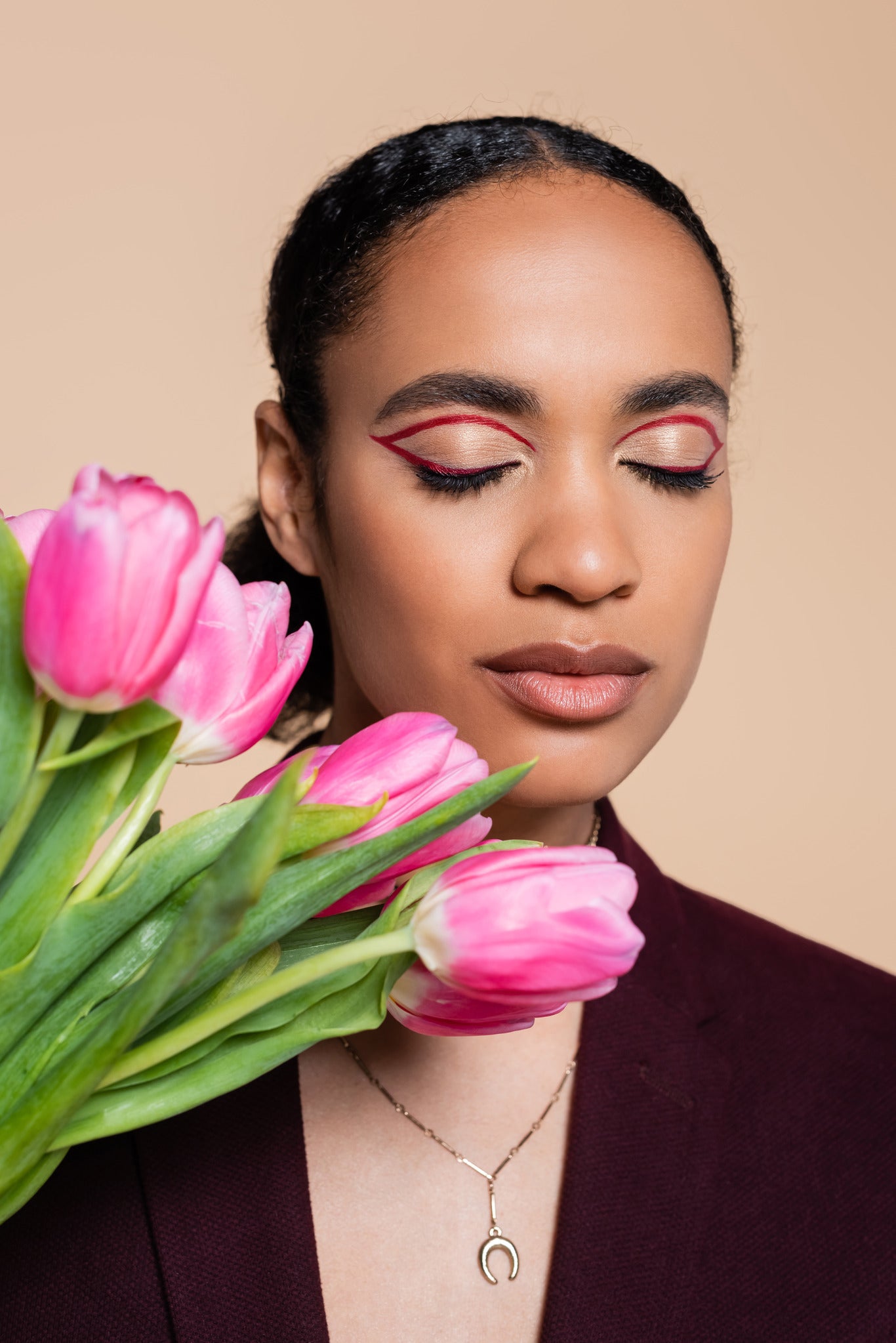 woman with red eye makeup and pink flowers 