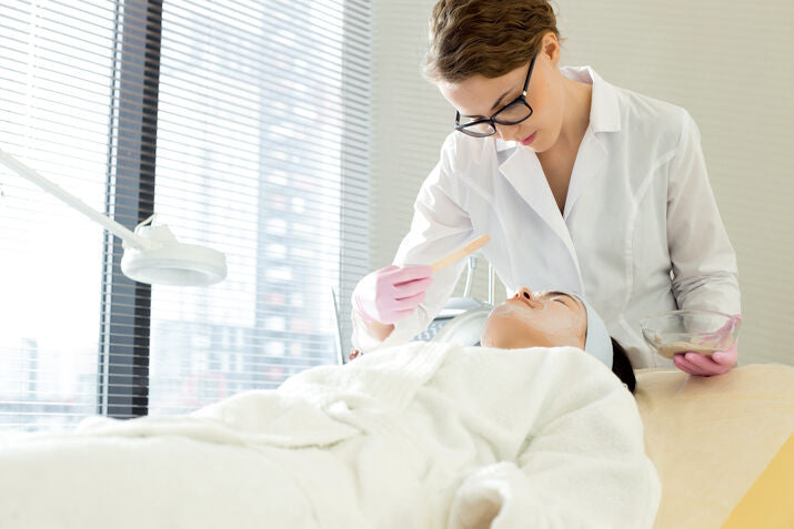 woman getting facial treatment by professional