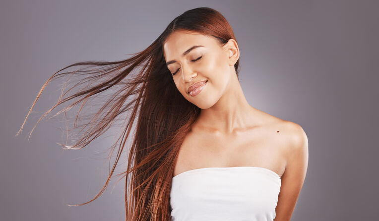 a woman with her eyes closed enjoys the wind in her hair
