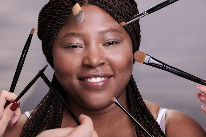 woman surrounded by makeup brushes 