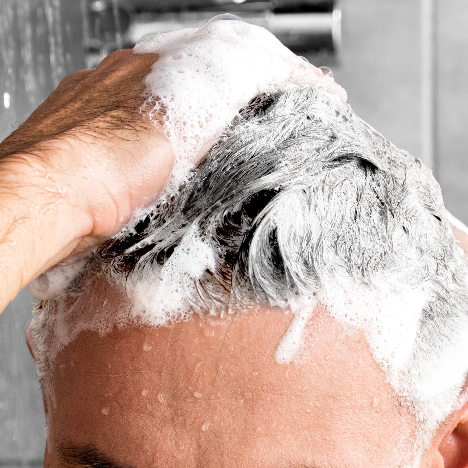 adult man washing hair with shampoo