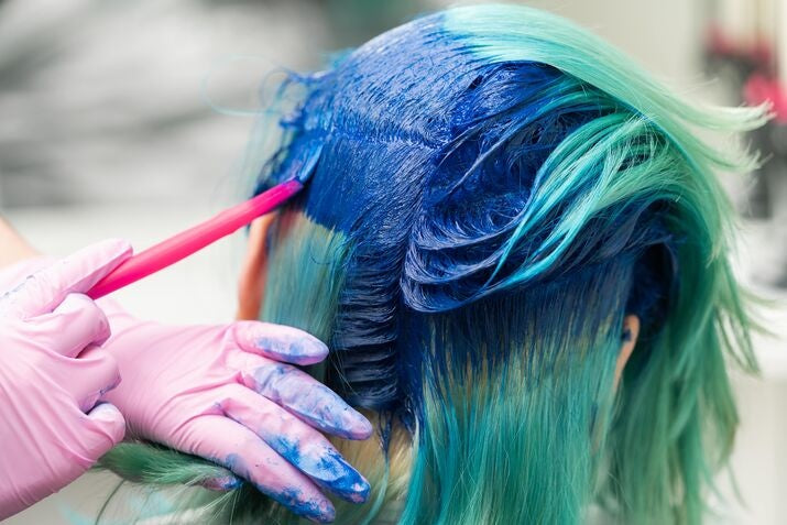 Woman getting her hair dyed blue