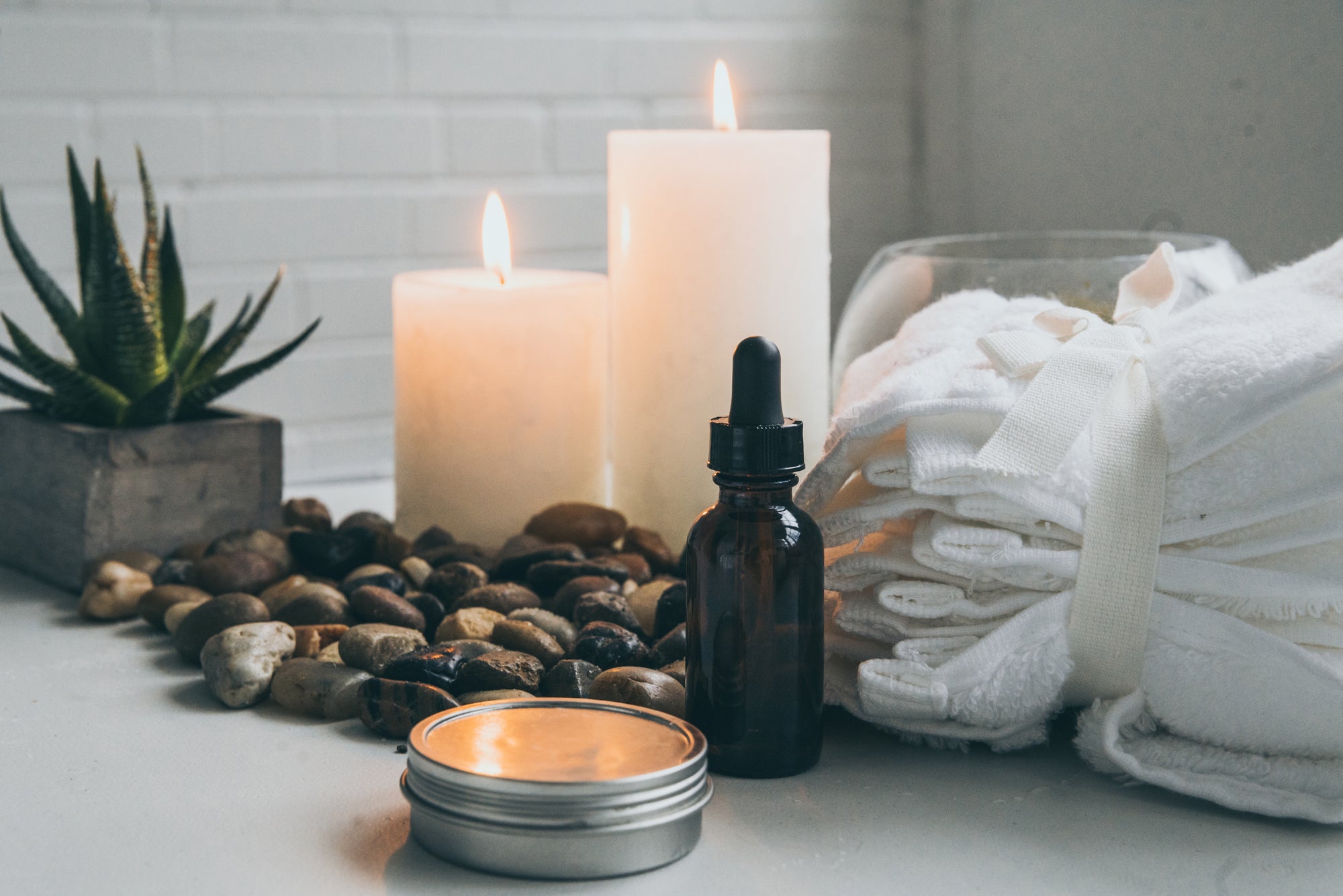 spa with candles towels plants and serum