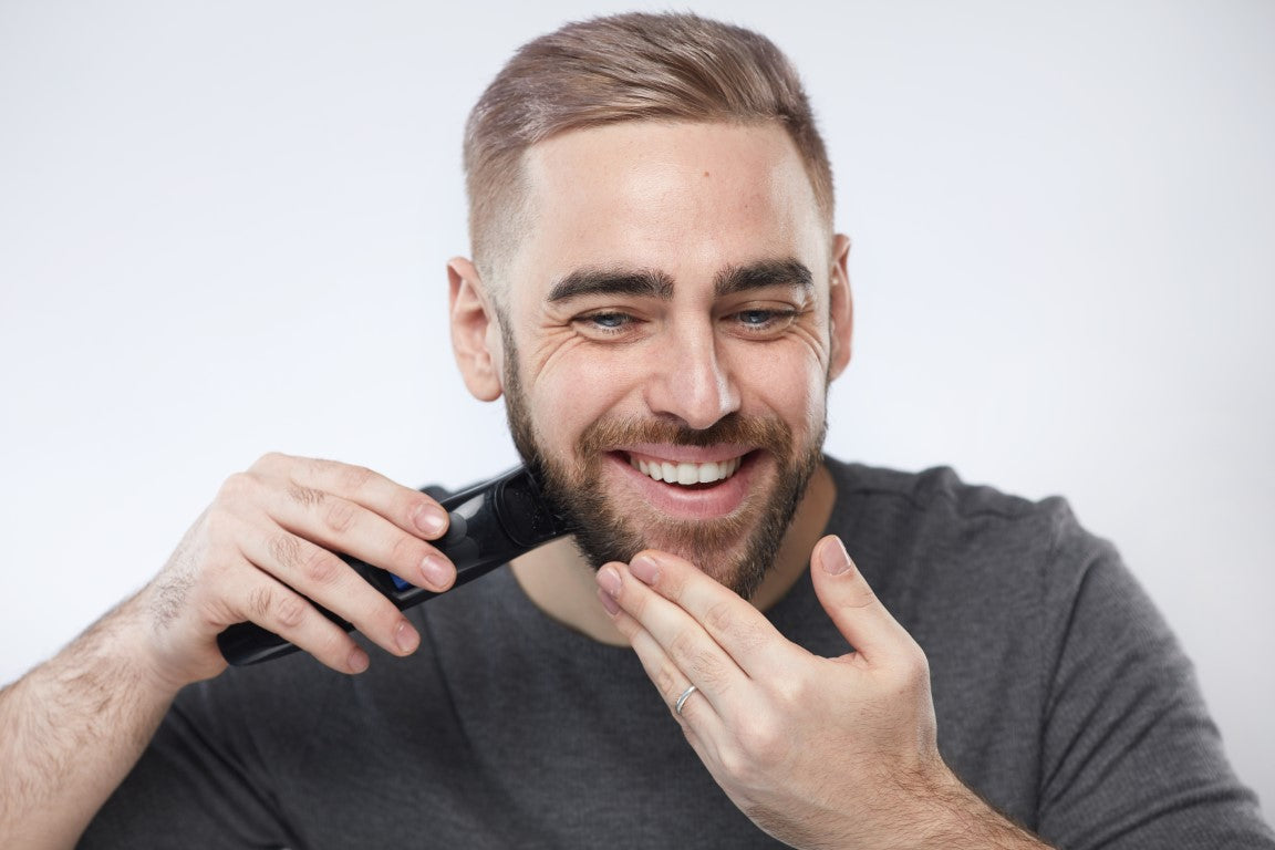 young man trimming beard 