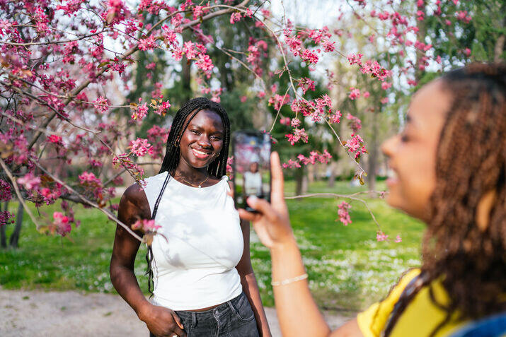 Two women taking picture in tree