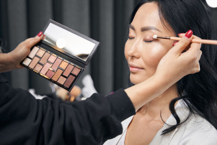 Woman having eyeshadow applied